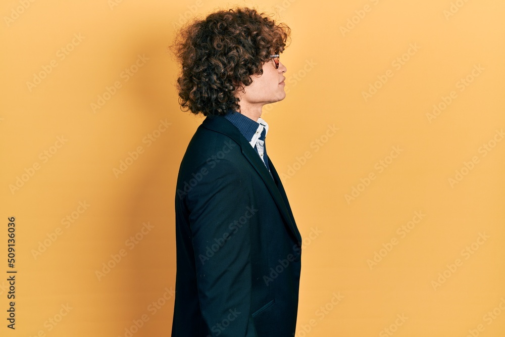 Obraz premium Handsome young man wearing business jacket and glasses looking to side, relax profile pose with natural face with confident smile.