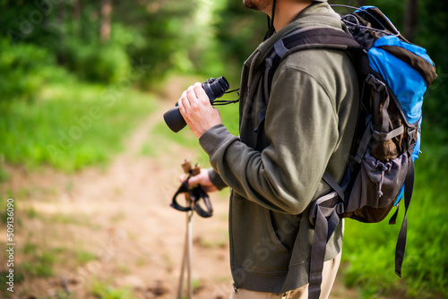 Image of man hiking and using binoculars.