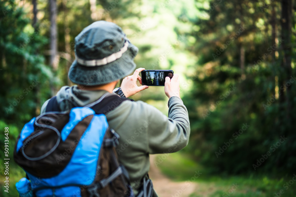 Image of man enjoys hiking and making pictures with his phone. Image of man enjoys hiking and making pictures with his phone.