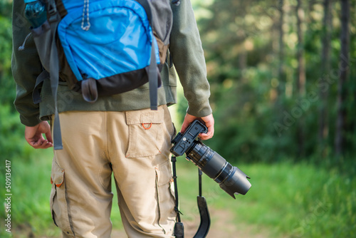 Image of man photographing while hiking in the nature.