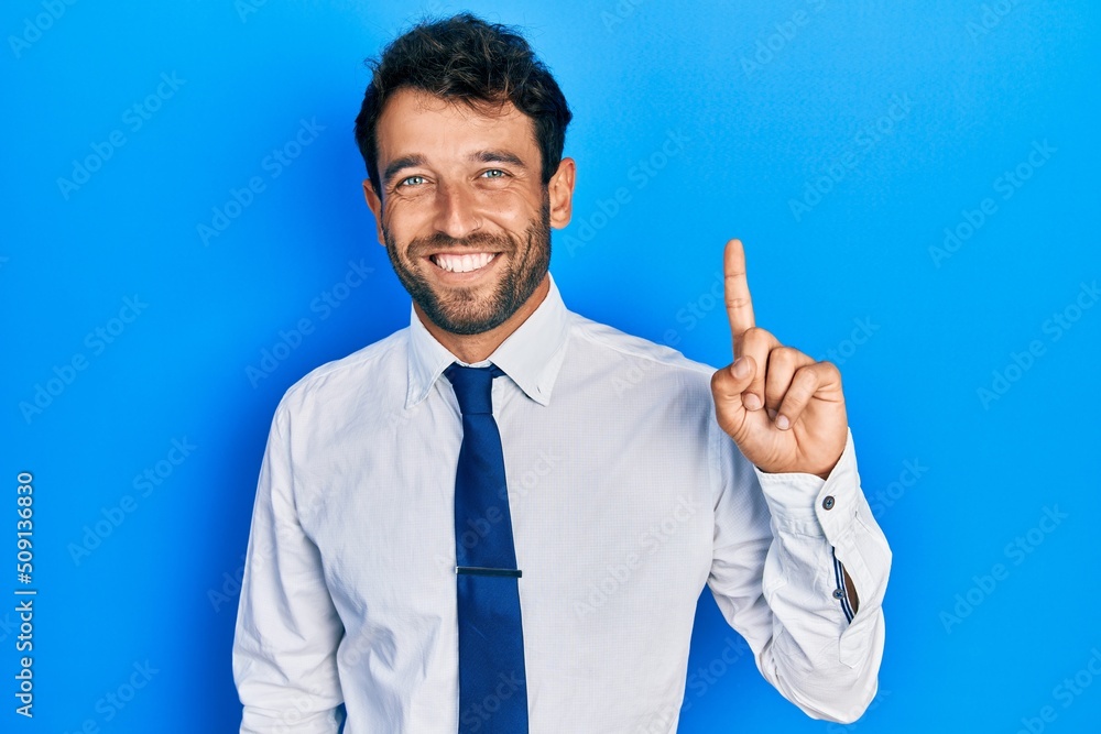 Handsome man with beard wearing business shirt and tie smiling with an idea or question pointing finger up with happy face, number one Handsome man with beard wearing business shirt and tie smiling with an idea or question pointing finger up with happy face, number one