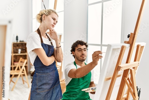 Paint teacher woman teaching to student man at art studio.