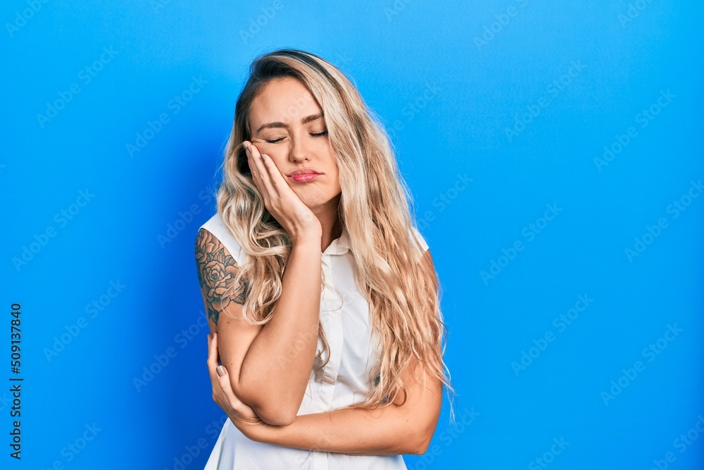 Beautiful young blonde woman wearing casual white shirt thinking looking tired and bored with depression problems with crossed arms. Beautiful young blonde woman wearing casual white shirt thinking looking tired and bored with depression problems with crossed arms.