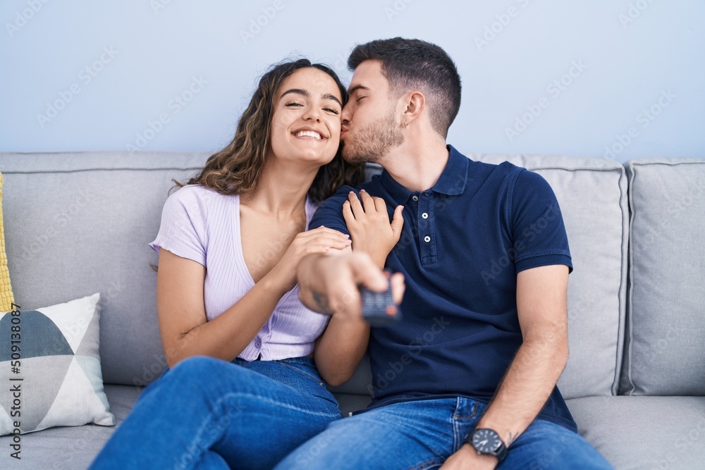 Young hispanic couple watching movie sitting on sofa at home Young hispanic couple watching movie sitting on sofa at home
