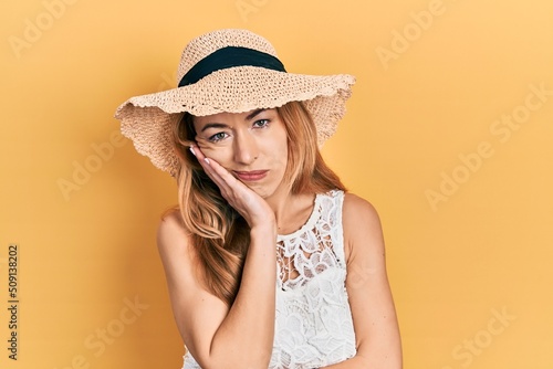 Young caucasian woman wearing summer hat thinking looking tired and bored with depression problems with crossed arms.