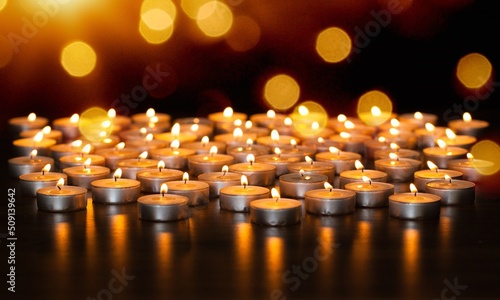 Many burning candles with beautiful bokeh light background