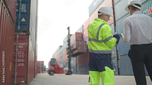 Caucasian cargo container worker and manager discuss together and plan about tranportation in front of working crane carry container tank.