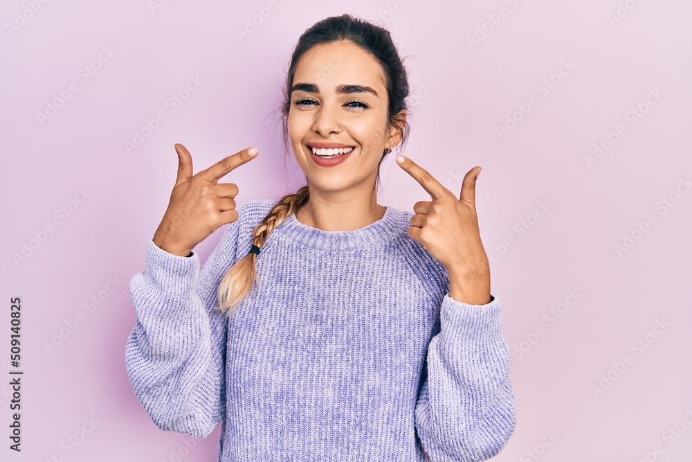 Young hispanic girl wearing casual clothes smiling cheerful showing and pointing with fingers teeth and mouth. dental health concept. Young hispanic girl wearing casual clothes smiling cheerful showing and pointing with fingers teeth and mouth. dental health concept.