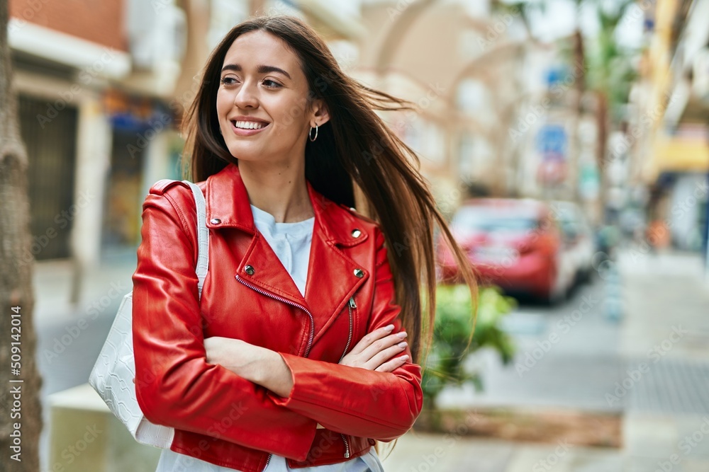 Young hispanic woman smiling happy with arms crossed at the city. Young hispanic woman smiling happy with arms crossed at the city.