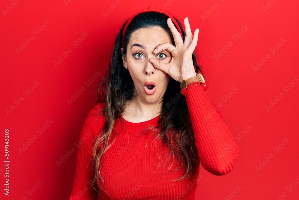 Young hispanic woman wearing casual clothes doing ok gesture shocked with surprised face, eye looking through fingers. unbelieving expression. Young hispanic woman wearing casual clothes doing ok gesture shocked with surprised face, eye looking through fingers. unbelieving expression.