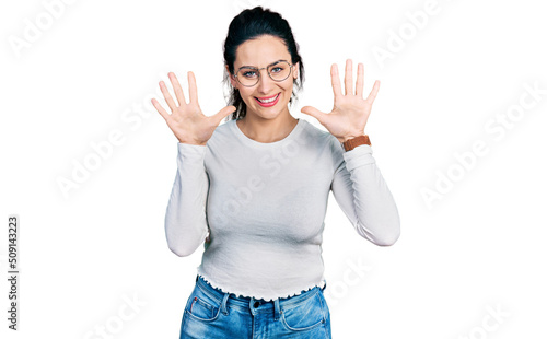 Young hispanic woman wearing casual clothes showing and pointing up with fingers number ten while smiling confident and happy.