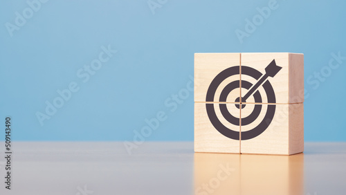 Wooden blocks with target icon on wooden table blue background copy space. The concept of strategy, goals.