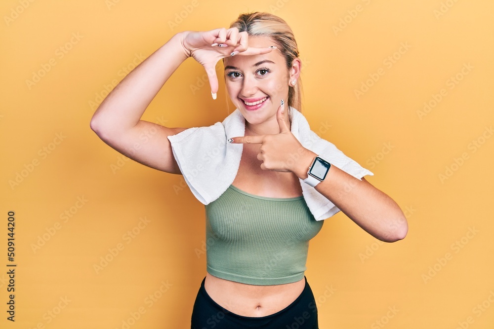 Young blonde girl wearing sportswear and towel smiling making frame with hands and fingers with happy face. creativity and photography concept. Young blonde girl wearing sportswear and towel smiling making frame with hands and fingers with happy face. creativity and photography concept.