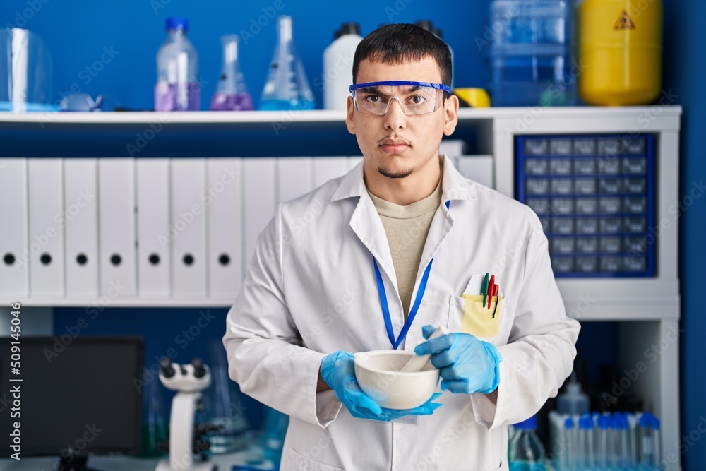 Young arab man working at scientist laboratory skeptic and nervous, frowning upset because of problem. negative person.