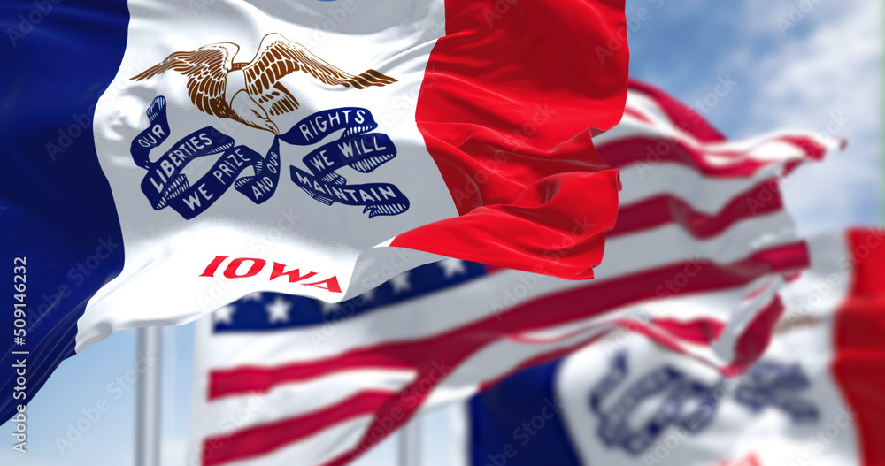 Naklejka premium The Iowa state flag waving along with the national flag of the United States of America
