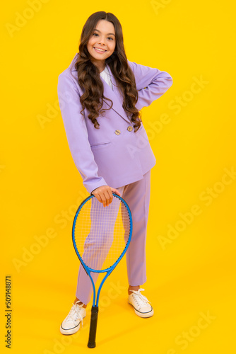 Tennis player hold tennis racket over isolated yellow studio background. Sport and fitness for kids. Fashion and sport concept. Teenager child with tennis racquet. © Olena
