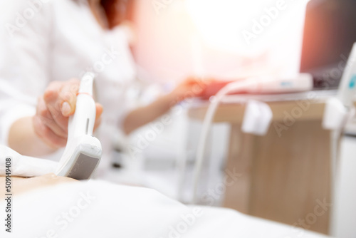 Closeup ultrasound scanner device in hand professional doctor woman use for examining patient female, sunlight photo