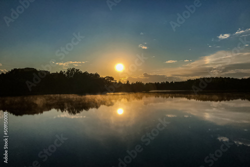 fog over lake water surface at sunset in summer