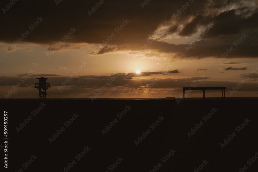Sunset behind the lifeguard station, on a Mediterranean beach