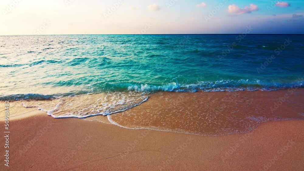Tropical sea at sunset. Maldivian beach with gentle rolling waves on the tropical island of Thulusdhoo in Maldives