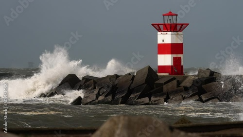 Storm at sea, winds, big waves hit lighthouse at Scheveningen, Den Haag, The Netherlands photo