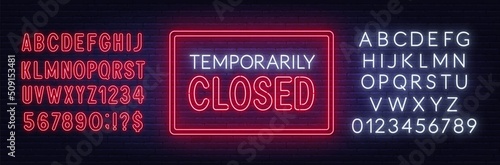 Temporarily closed neon sign on brick wall background.