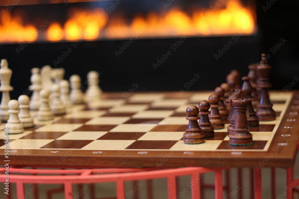 Modern glass corner fireplace wall in the interior. Game. Success. Sports. Chess financial business strategy concept. Great Chess board. Modern glass corner fireplace wall in the interior. Game. Success. Sports. Chess financial business strategy concept. Great Chess board.