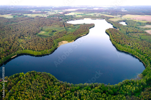 Widok z góry jezioro Wierzchowo w Polsce. Zielony las otaczający jezioro i czysta niebieska woda Krajobraz wiejski w Polsce. © hunter76