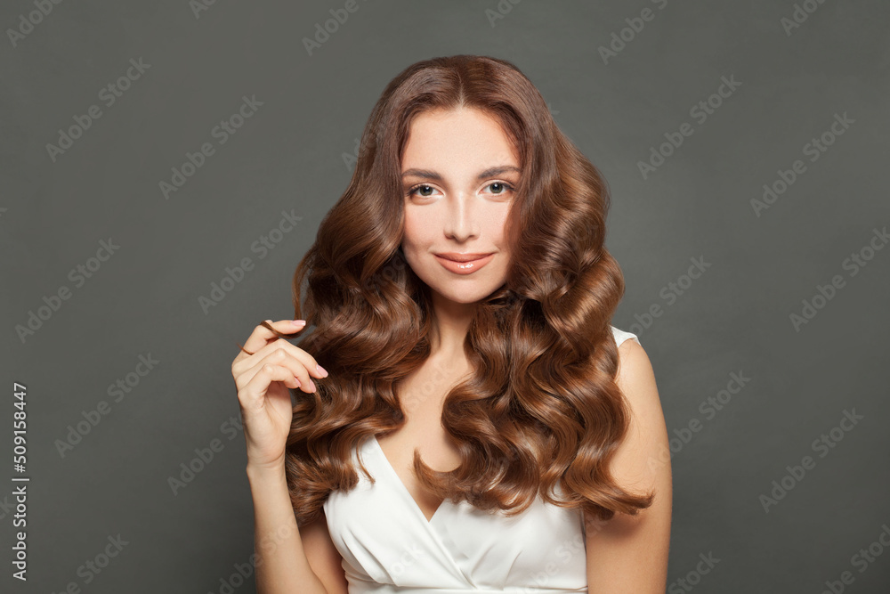 Beautiful young woman with long wavy and shiny hair. Brunette woman with curly hairstyle Beautiful young woman with long wavy and shiny hair. Brunette woman with curly hairstyle