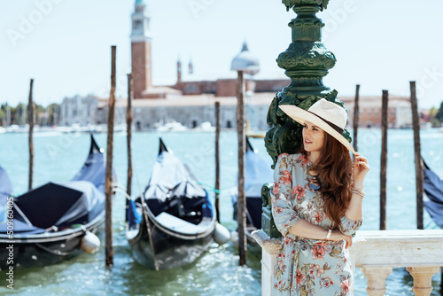 pensive trendy solo traveller woman in floral dress with hat © Alliance