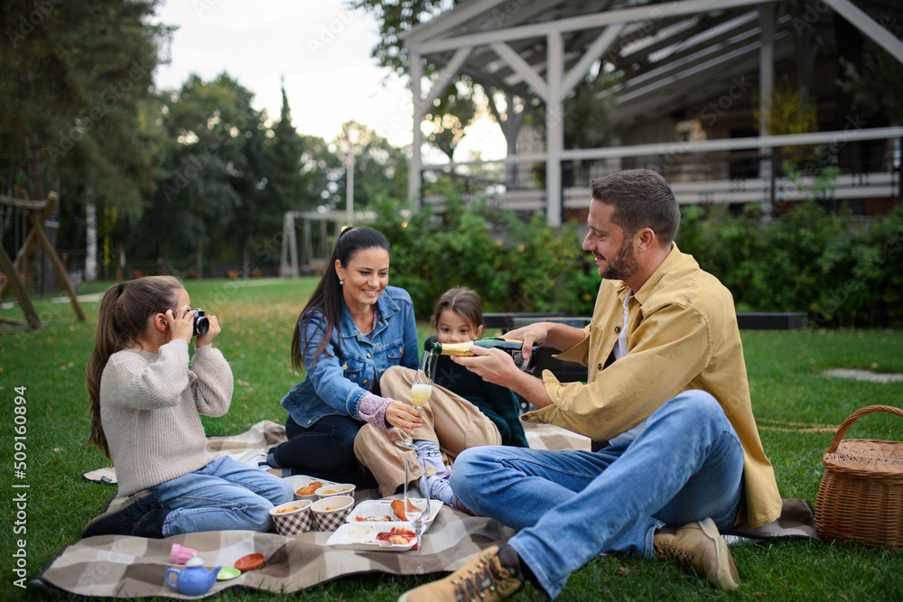 Happy young family sitting on blanket and having take away picnic outdoors in restaurant area. Happy young family sitting on blanket and having take away picnic outdoors in restaurant area.