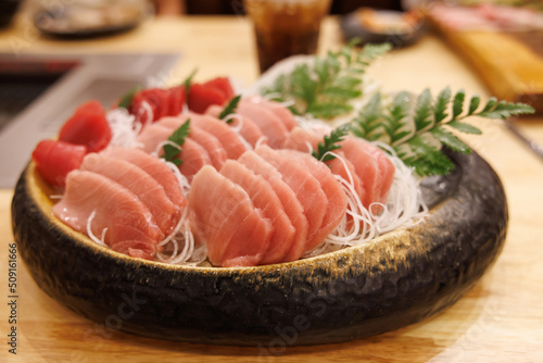 High grade fatty tuna fillet on wooden table in japanese restaurant. raw fish meat. Otaro or Sesami.