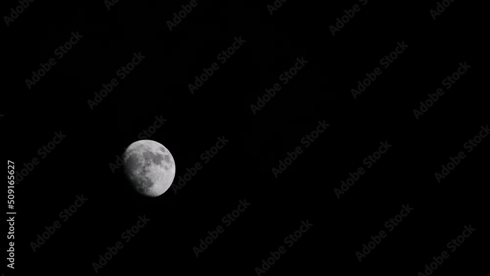 Half Moon in the night sky, emerging from behind black clouds. The moon's serene glow creates a contrast against the dark backdrop, offering ample copy space for your creative projects. Half Moon in the night sky, emerging from behind black clouds. The moon's serene glow creates a contrast against the dark backdrop, offering ample copy space for your creative projects.