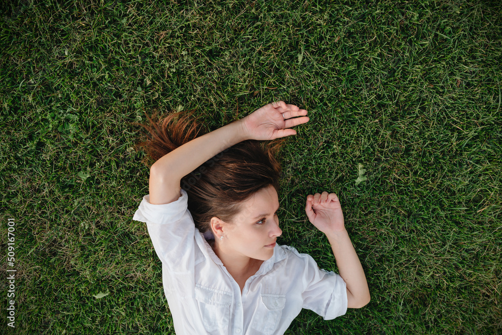 shot of woman lying on green grass shot of woman lying on green grass