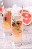 Paloma cocktail or lemonade with lime, grapefruit, blueberries and rosemary. Refreshing organic drink