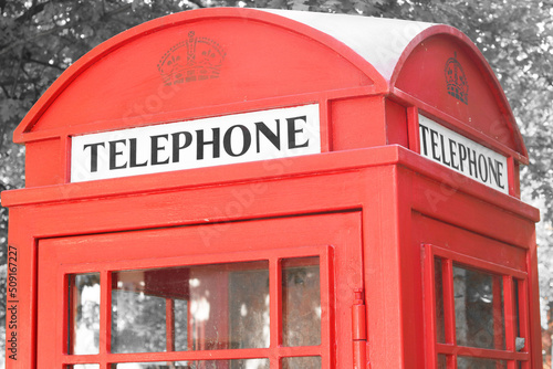 Black and white photo with red telephone booth in classic english style on black and white background in style of black and white retro photo as sample of black and white photo with red accent
