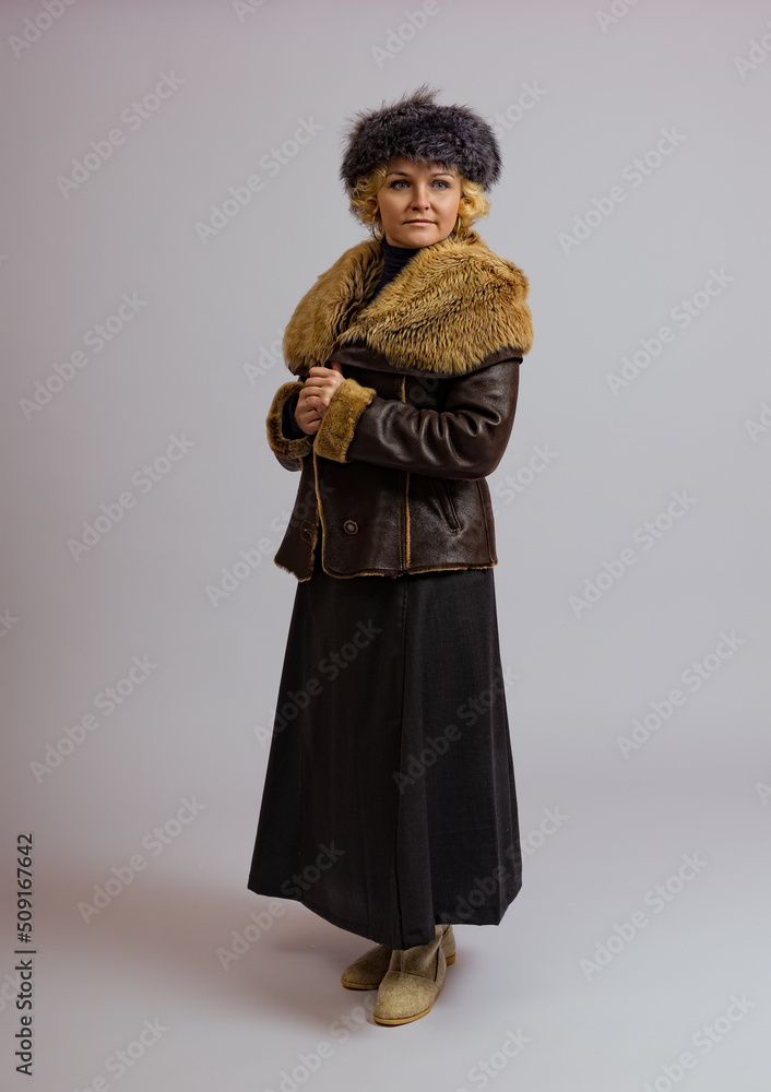 woman in warm fur clothes posing in full growth on a white background