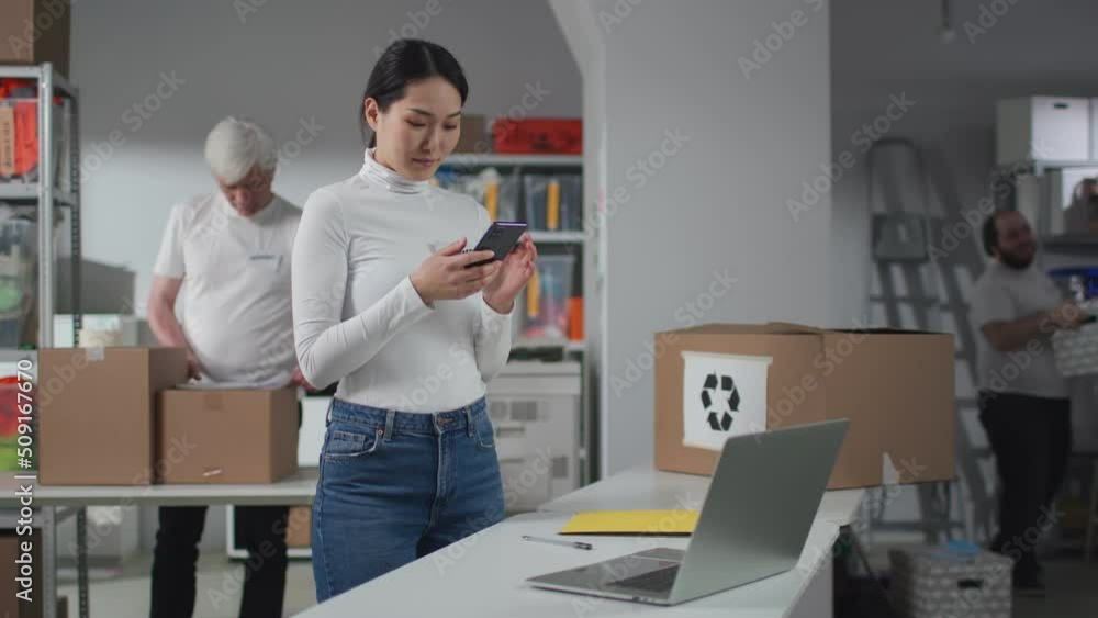 Recycling center manager use smartphone working with team in sorting center Recycling center manager use smartphone working with team in sorting center