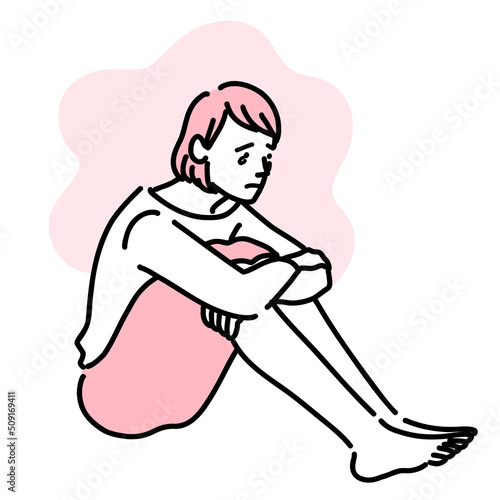 気持ちが落ち込んで体育座りで悩んでいる女性