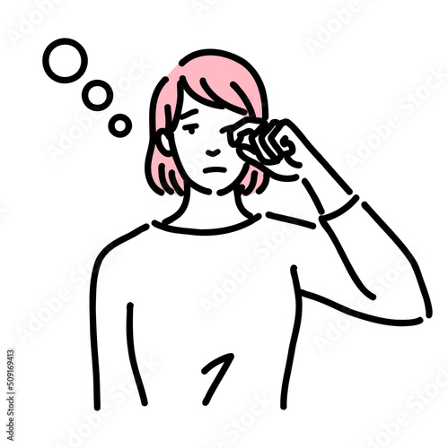 眠そうに目を擦っている若い女性
