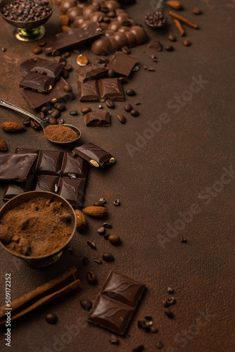 Chocolate background with chocolate pieces, chocolate chips, nuts, cocoa