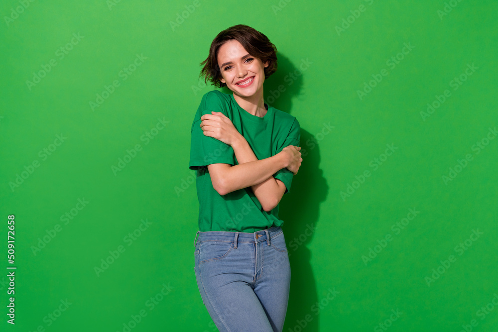 Photo of stunning nice person toothy smile embrace shoulders isolated on green color background Photo of stunning nice person toothy smile embrace shoulders isolated on green color background