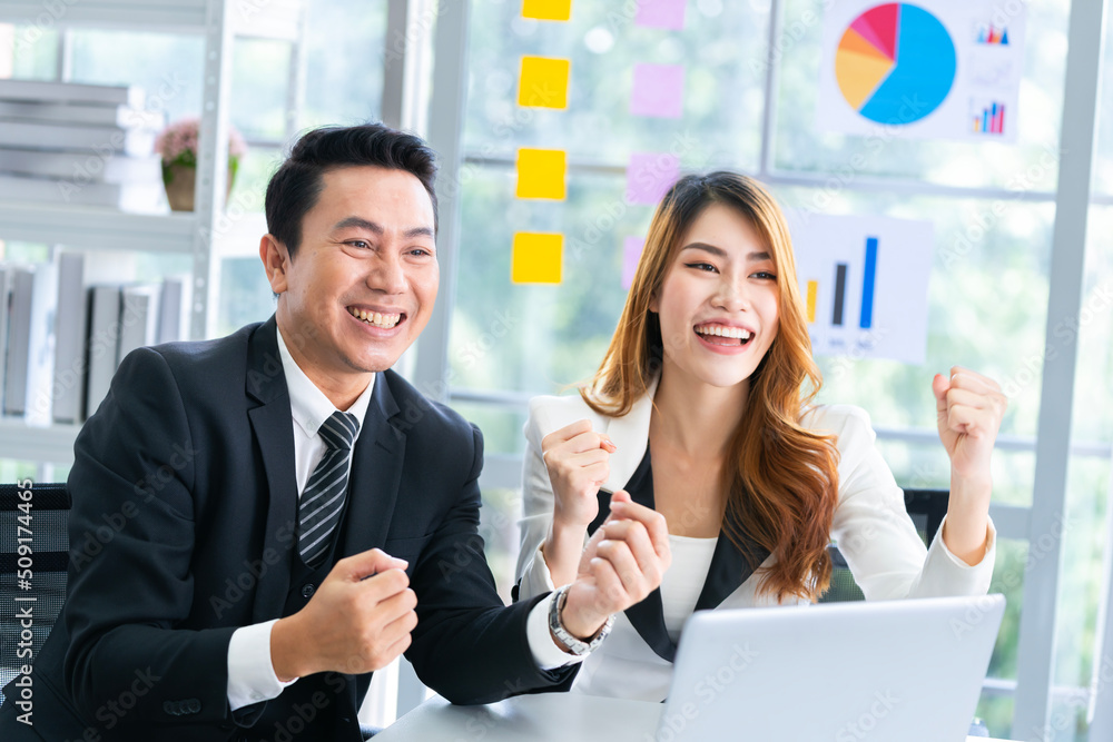 A group of young businessmen in suits, Asians, are determined and excited about their work. and encourage the team members by raising their hands happily A group of young businessmen in suits, Asians, are determined and excited about their work. and encourage the team members by raising their hands happily