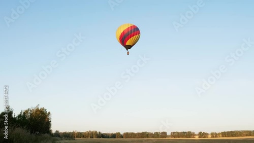 Sunrise flight of hot air balloon aerial drone view. Over farming fields.