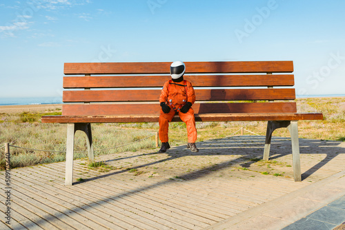 Spaceman sitting on giant bench photo