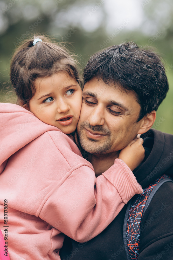 Daughter hugs her father in nature. Casual style, day, summer, sincere emotions Daughter hugs her father in nature. Casual style, day, summer, sincere emotions