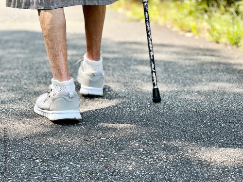 杖をついて歩く高齢女性の足のアップ