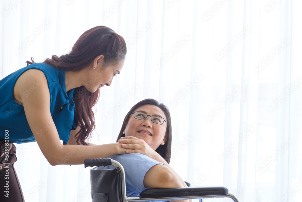 adult daughter hand holding hand of senior mother in wheelchair while visiting doctor adult daughter hand holding hand of senior mother in wheelchair while visiting doctor