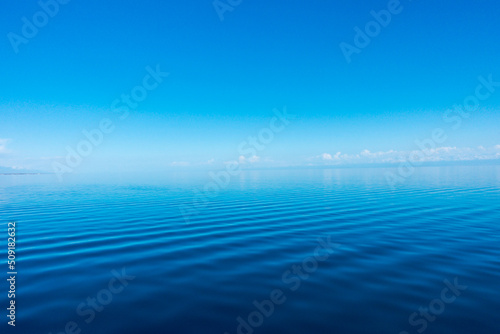 Clear water texture in blue and orange. Background of the ocean and the sea backlit by the sun. Natural water