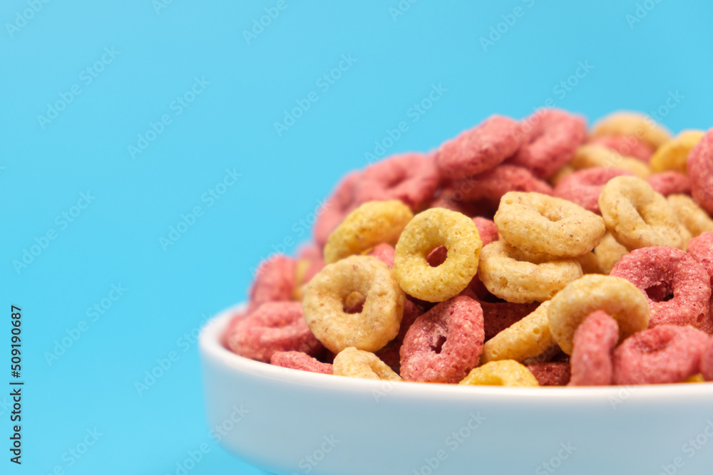 Quick cereal breakfast in the form of rings on a plate on a blue background Quick cereal breakfast in the form of rings on a plate on a blue background